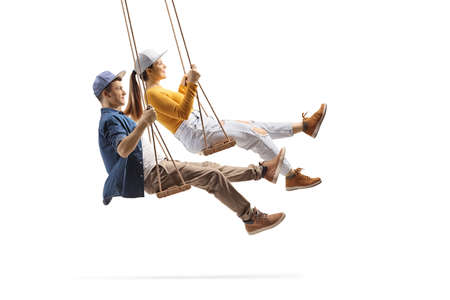 Profile shot of male and female teens swinging on wooden swings isolated on white background