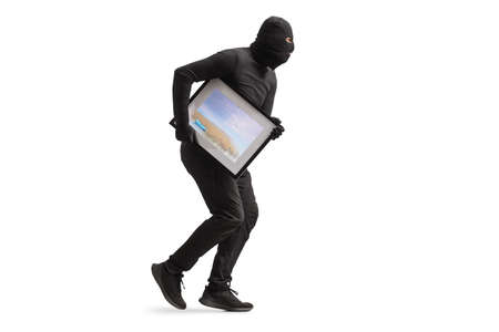 Burglar in black clothes and balaclava stealing a painting isolated on white background