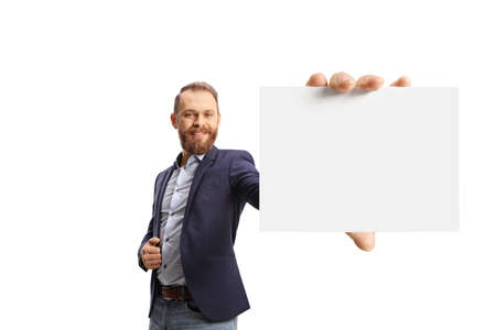 Smiling young bearded man holding a blank card in front of camera isolated on white backgroundの写真素材