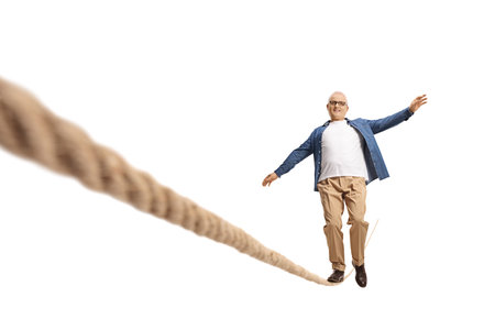 Full length portrait of a mature man stumble on a rope isolated on white backgroundの写真素材