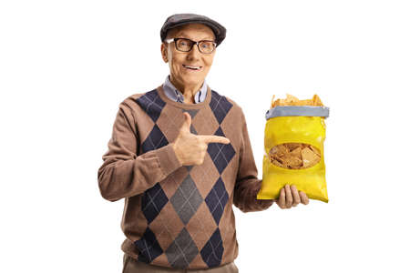 Cheerful elderly man holding a pack of tortilla chips and pointing isolated on white background