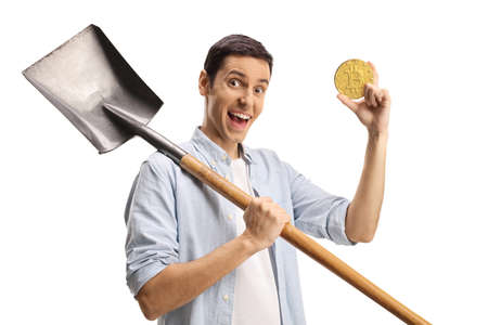Casual guy holding a shovel and a bitcoin isolated on white backgroundの写真素材
