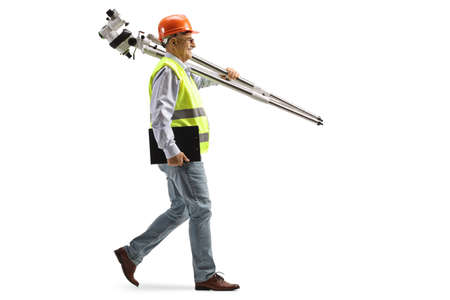 Full length profile shot of an engineer walking and carrying measuring instrument isolated on white...