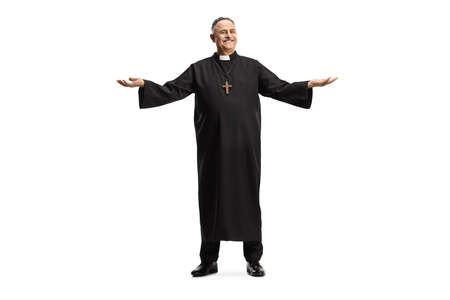 Full length portrait of a smiling mature priest standing and spreading arms isolated on white...