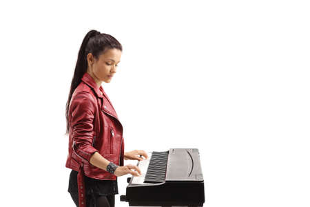 Profile shot of a young woman playing a digital piano isolated on white background