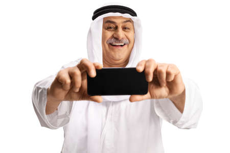 Mature arab man taking a selfie photo with a smartphone isolated on white backgroundの写真素材