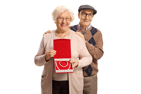 Elderly man and woman holding a box with a pearl necklace and bracelet isolated on white backgroundの写真素材