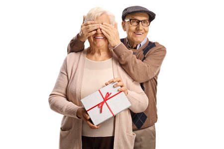 Elderly man giving a surprise gift to an elderly woman isolated on white backgroundの写真素材