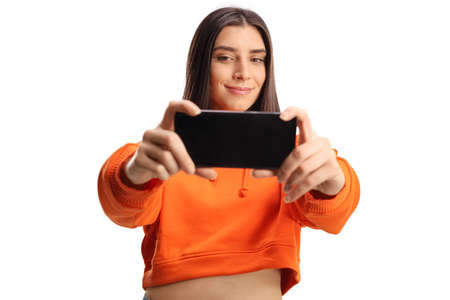 Trendy young woman taking a photo with a cellphone isolated on white background