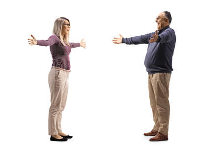Full length profile shot of a young woman spreading arms to hug her father isolated on white backgroundの写真素材