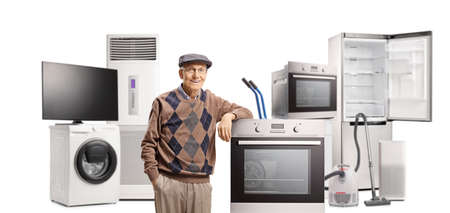 Elderly man posing with different electrical household appliances isolated on white backgroundの写真素材
