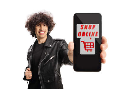 Young man in leather jacket showing a smartphone with text shop online isolated on white background