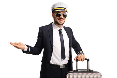 Pilot in a uniform with a suitcase pointing with hand isolated on white backgroundの写真素材
