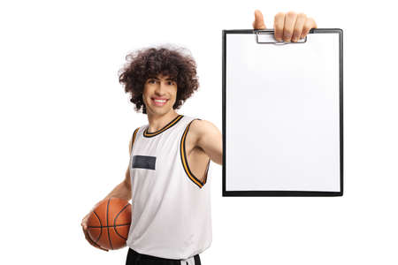Basketball player holding a ball and showing a blank paper document with a clipboard isolated on white backgroundの写真素材