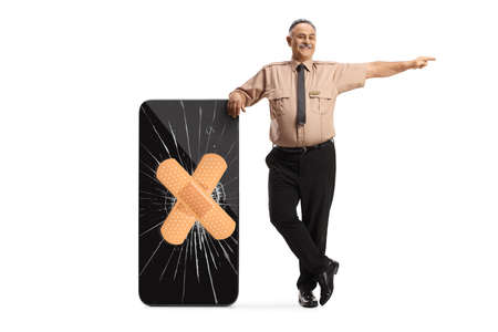 Security guard leaning on a broken smartphone fixed with adhesive bandage and pointing isolated on...