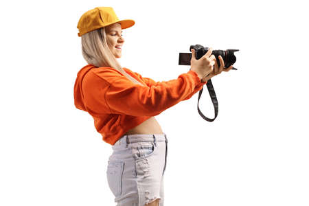 Profile shot of a female teenager recording with a professional camera isolated on white backgroundの写真素材