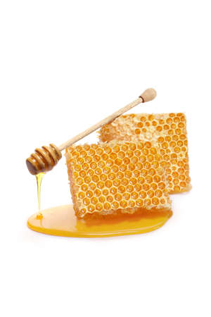 Pieces of a honeycomb with a honey dipper isolated on white background