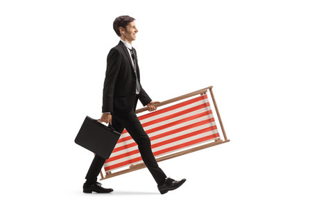 Businessman walking and carrying a beach chair and a briefcase isolated on white backgroundの写真素材