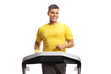 Man in sportswear running on a treadmill and looking at camera isolated on white backgroundの写真素材