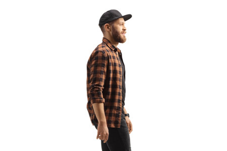 Profile shot of a young trendy man in a shirt and cap isolated on white background