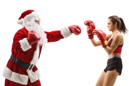 Profile shot of santa claus boxing with a young woman isolated on white backgroundの写真素材