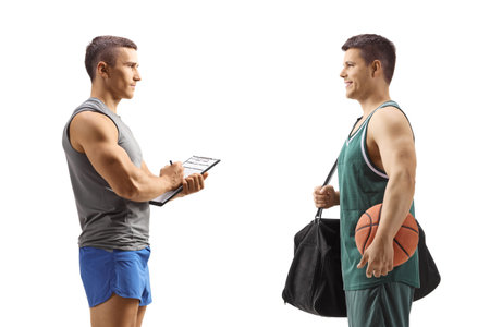 Fitness trainer talking to a basketball player isolated on white backgroundの写真素材