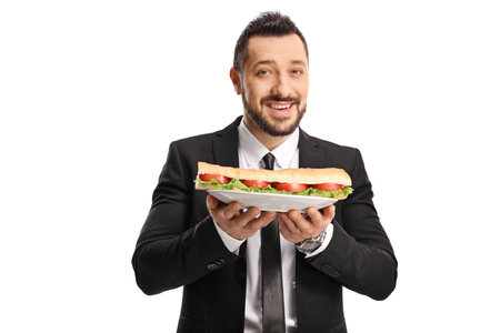 Businessman holding a sandwich on a plate isolated on white backgroundの写真素材