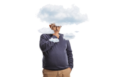 Mature man standing and thinking with clouds around his head isolated on white backgroundの写真素材
