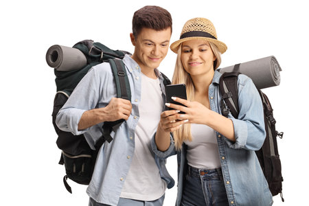 Young male and female backpackers looking at a smartphone isolated on white backgroundの写真素材