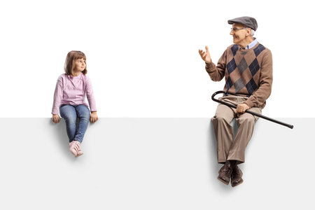 Girl sitting on a blank panel and listening to grandfather isolated on white backgroundの写真素材