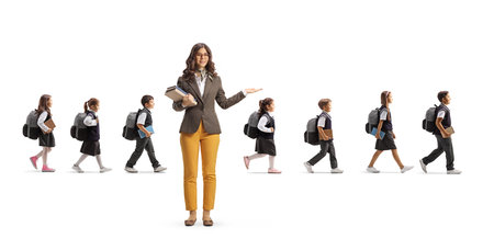 Teacher pointing with hand and schoolchildren walking behind isolated on white backgroundの写真素材