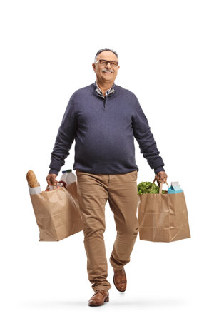 Full length portrait of a mature man carrying grocery bags isolated on white backgroundの写真素材