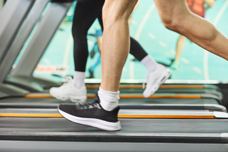 Shot of male and female legs running on treadmills in a gymの写真素材