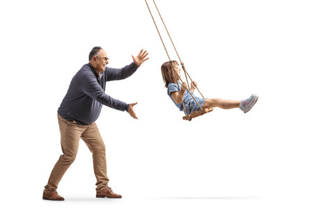 Grandad pushing a little girl on a swing isolated on white backgroundの写真素材