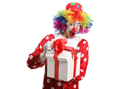 Clown peeking at a present box isolated on white backgroundの写真素材