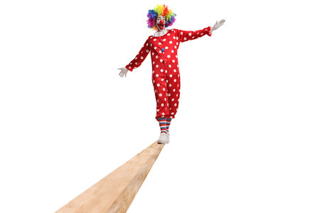Full length portrait of a clown in red costume walking on a beam isolated on white backgroundの写真素材