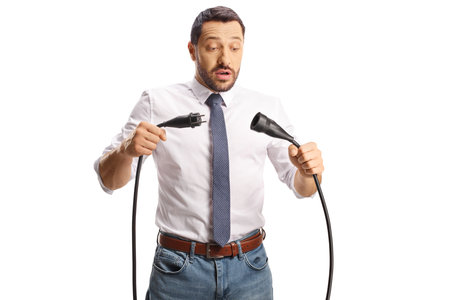 Young man unplugging cables isolated on white backgroundの写真素材