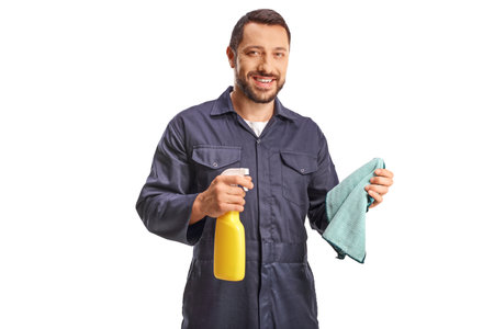 Mechanic holding a wiping cloth and a cleaning spray isolated on white background