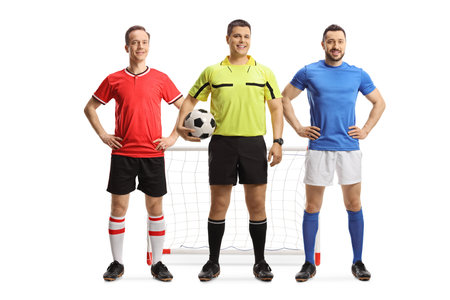 Football players and a referee holding a ball in front of a goal isolated on white background