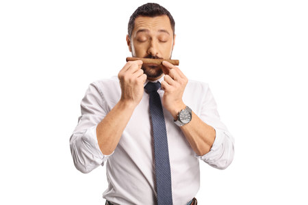 Young man smelling a cigar isolated on white backgroundの写真素材
