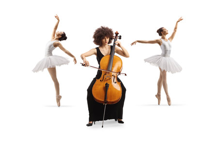 Elegant young woman in a black dress playing a contrabass and two ballerinas dancing in the back isolated on white backgroundの写真素材