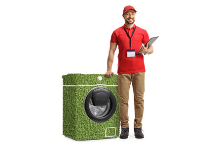 Full length portrait of a sale assitant leaning on a power efficient washing machine isolated on...