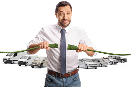 Man holding green cables in front of parked vehicles isolated on white backgroundの写真素材