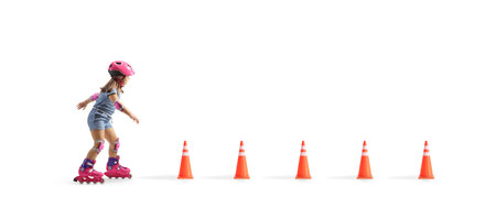 Happy little girl riding roller blades between obstacle cones isolated on white backgroundの写真素材