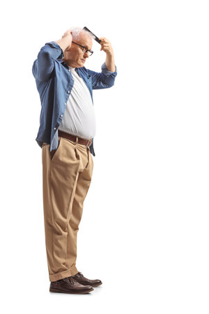 Full length profile shot of a mature man combing hair isolated on white backgroundの写真素材