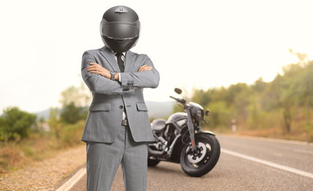 Businessman biker with a helmet standing on a road
