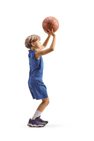 Full lenggth profile shot of a boy shooting a basketball isolated on white backgroundの写真素材