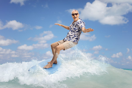 Elderly man riding a surfboard in the sea