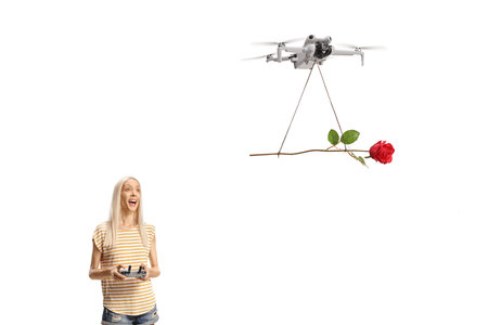 Young woman flying a drone with a rose isolated on white background