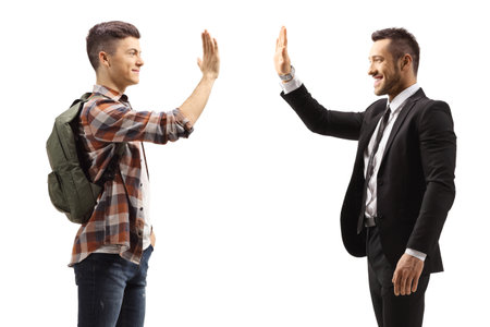 Profile shot of a male student gesturing high-five with a businessman isolated on white background